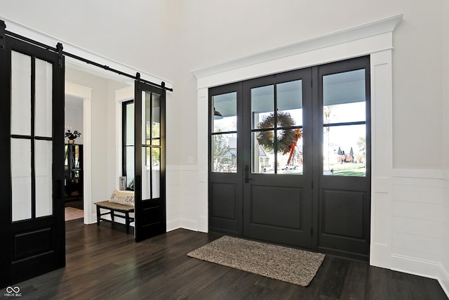10725 Holliday Farms Blvd, Zionsville, IN 46077 - entryway with a barn door, a decorative wall, wainscoting, and dark wood-style floors