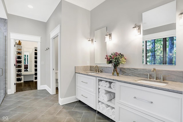 10725 Holliday Farms Blvd, Zionsville, IN 46077 - bathroom with a spacious closet, double vanity, tile patterned flooring, a stall shower, and baseboards