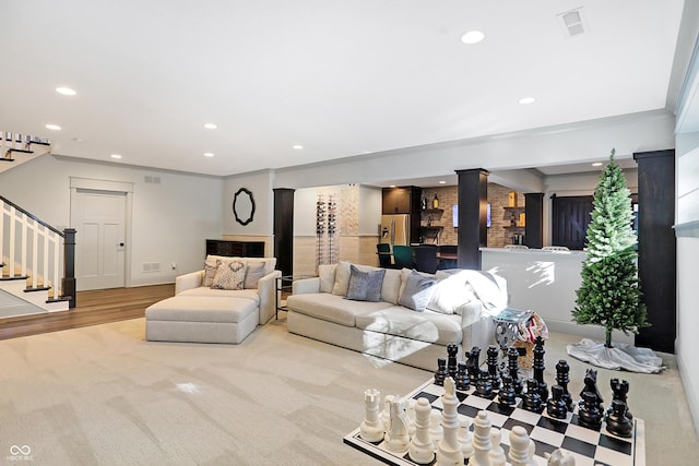 10725 Holliday Farms Blvd, Zionsville, IN 46077 - carpeted living room featuring decorative columns, stairs, recessed lighting, baseboards, and wood finished floors