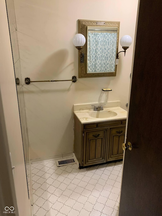 bathroom with tile patterned floors, visible vents, baseboards, and vanity