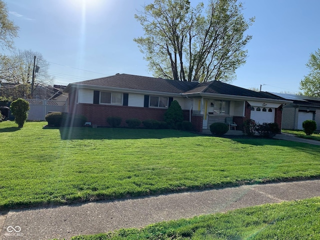 single story home featuring brick siding, an attached garage, fence, and a front yard