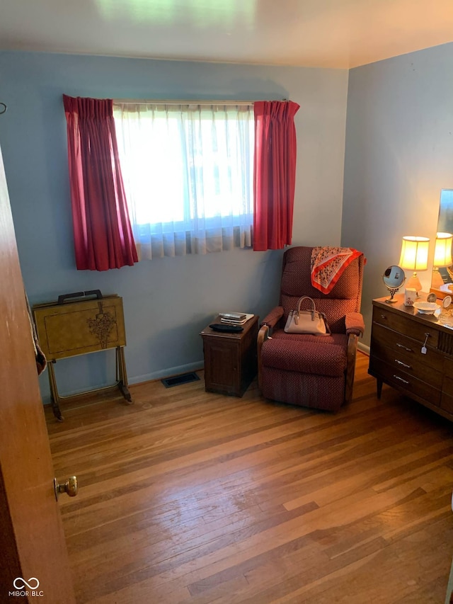 sitting room featuring wood finished floors and visible vents