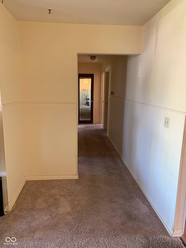 corridor featuring carpet floors and baseboards