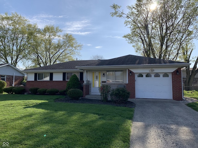 single story home featuring concrete driveway, an attached garage, a front yard, and brick siding