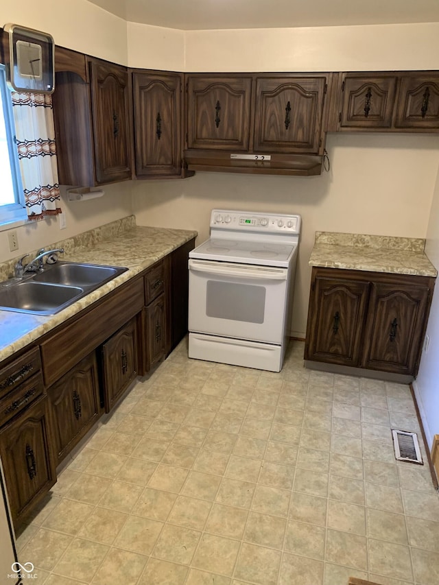 kitchen with light countertops, electric range, dark brown cabinetry, and a sink