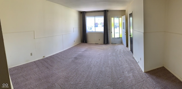 carpeted spare room featuring baseboards
