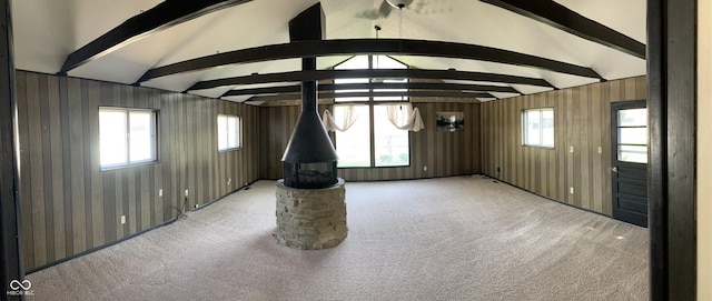 unfurnished living room with carpet flooring and lofted ceiling with beams