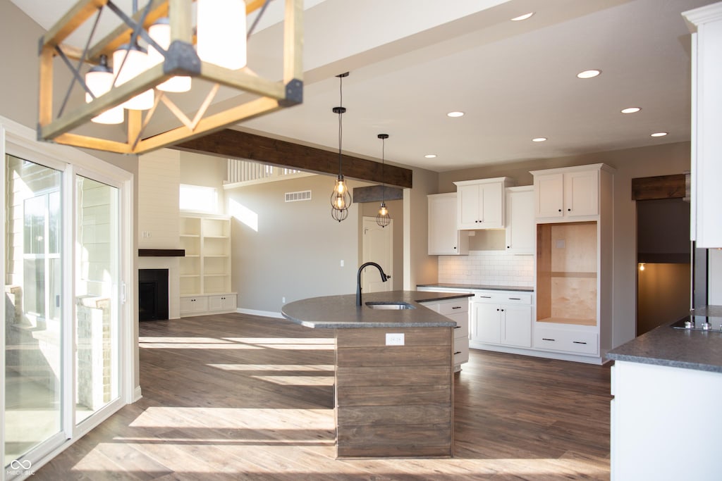 kitchen with a sink, recessed lighting, dark wood-style floors, and visible vents