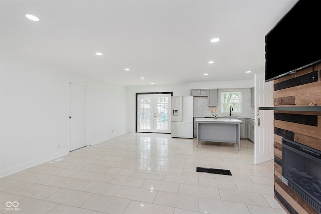 8041 Barry Rd, Indianapolis, IN 46219 - living area featuring a glass covered fireplace, recessed lighting, french doors, baseboards, and light tile patterned floors