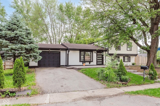 8041 Barry Rd, Indianapolis, IN 46219 - tri-level home featuring a garage, asphalt driveway, fence, and a shingled roof