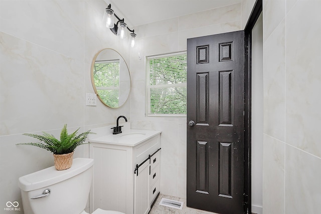 8041 Barry Rd, Indianapolis, IN 46219 - bathroom featuring toilet, tile walls, and vanity