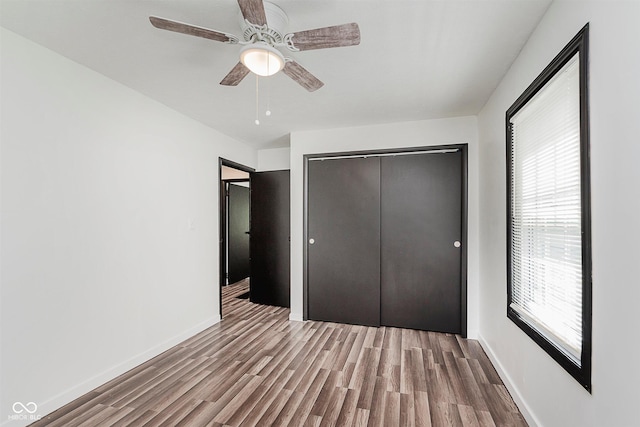 8041 Barry Rd, Indianapolis, IN 46219 - unfurnished bedroom with wood finished floors, a closet, baseboards, and ceiling fan