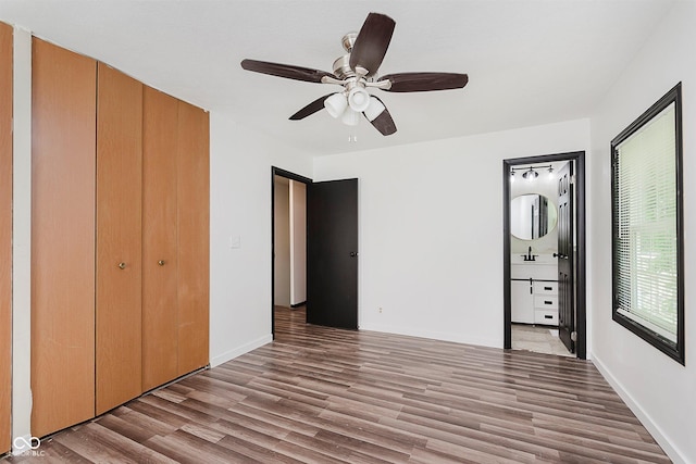 8041 Barry Rd, Indianapolis, IN 46219 - unfurnished bedroom featuring wood finished floors, ceiling fan, ensuite bathroom, a closet, and baseboards