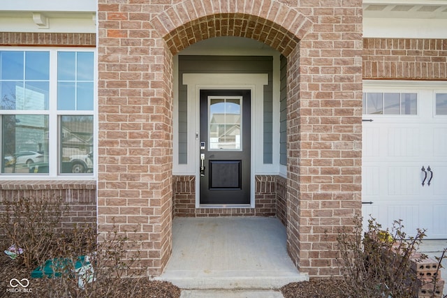 doorway to property featuring brick siding