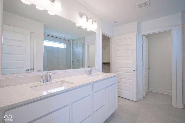 bathroom featuring a shower stall, visible vents, tile patterned flooring, and a sink