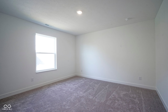 unfurnished room featuring visible vents, baseboards, and carpet flooring