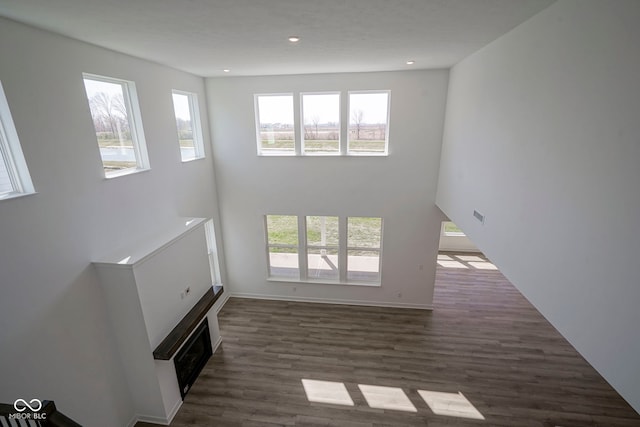 unfurnished living room featuring recessed lighting, baseboards, visible vents, and dark wood-type flooring