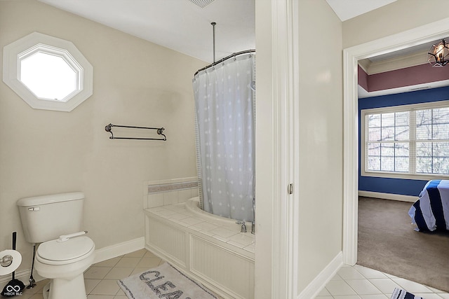 bathroom with tile patterned floors, baseboards, and a bathing tub