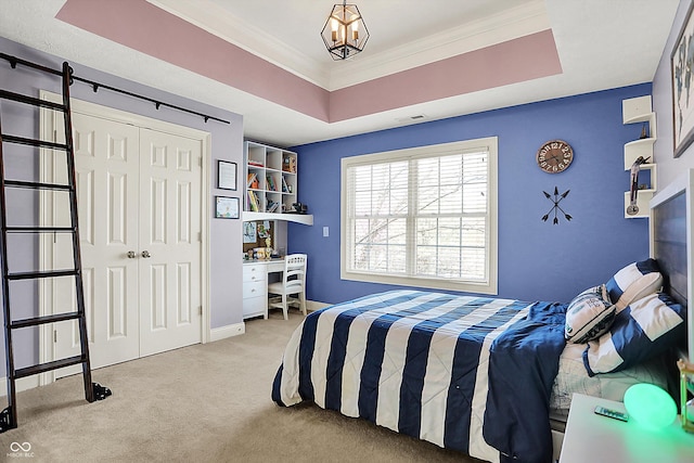 bedroom with a raised ceiling, carpet, visible vents, ornamental molding, and a closet