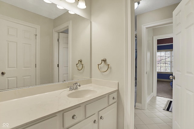 bathroom with tile patterned flooring, baseboards, and vanity