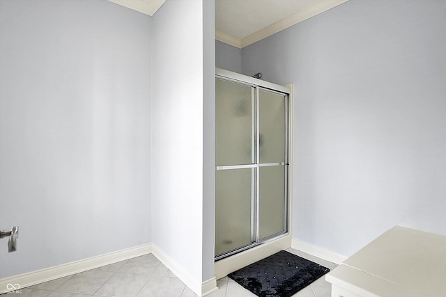 bathroom featuring crown molding, tile patterned floors, baseboards, and a stall shower