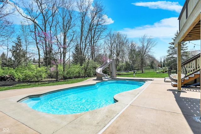 outdoor pool with stairway, a patio, a yard, and a water slide