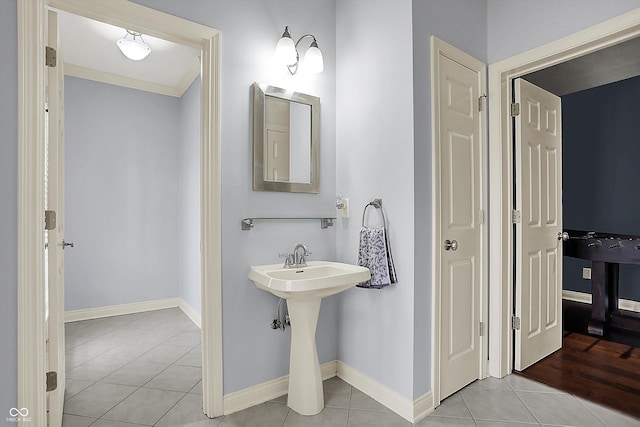 bathroom featuring baseboards, a sink, and tile patterned floors