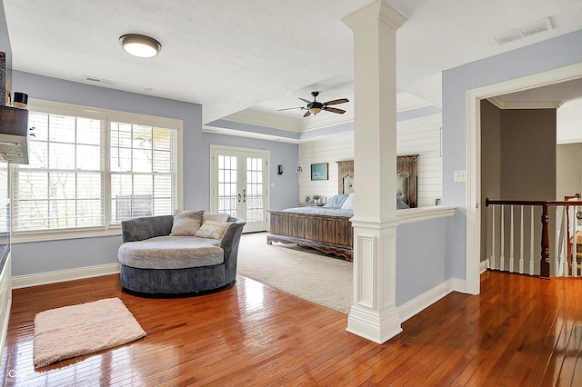 interior space with visible vents, a ceiling fan, baseboards, and wood-type flooring