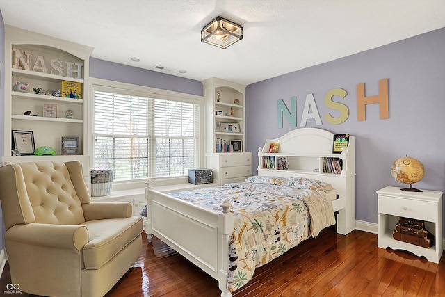 bedroom with baseboards, visible vents, and dark wood-type flooring