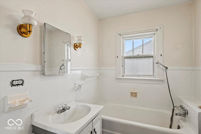 full bathroom with vanity, a bathtub, and wainscoting