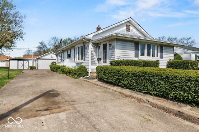 view of front of home with an outdoor structure, a garage, and a chimney
