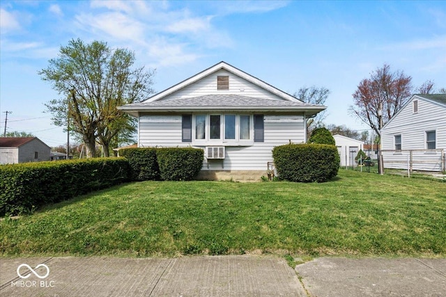 bungalow featuring a front lawn and fence