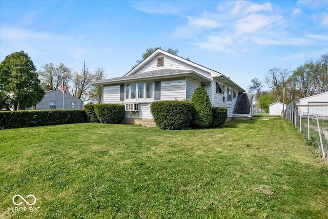 view of property exterior with fence and a lawn