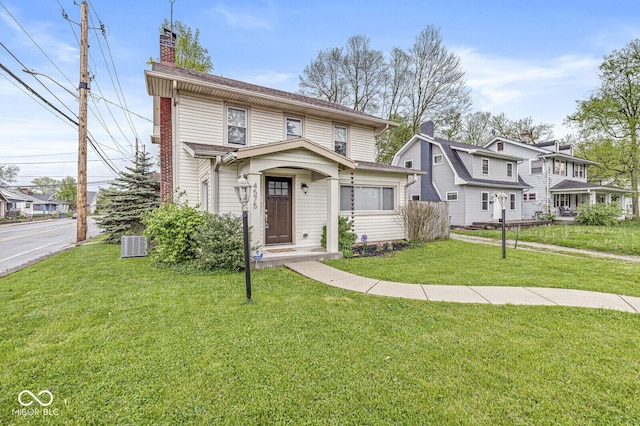 view of front of house with a front lawn, a chimney, and cooling unit