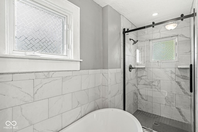full bath featuring recessed lighting, a freestanding bath, and a shower stall