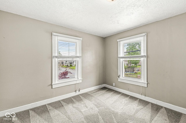 unfurnished room featuring baseboards, carpet flooring, and a textured ceiling