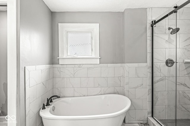 bathroom featuring marble finish floor, a soaking tub, and a shower stall