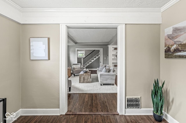 hall with baseboards, visible vents, wood finished floors, and stairway
