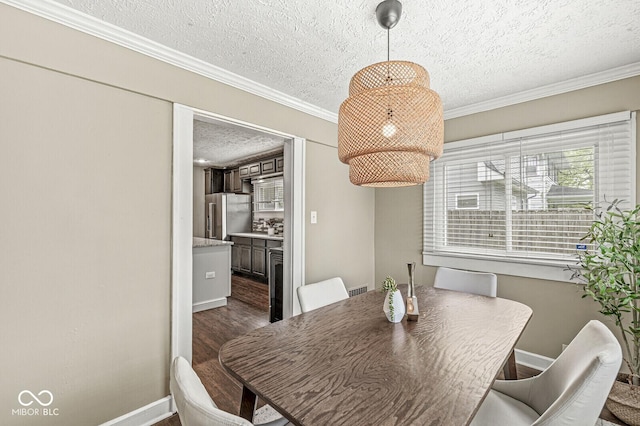 dining area featuring dark wood-style flooring, a textured ceiling, ornamental molding, and baseboards