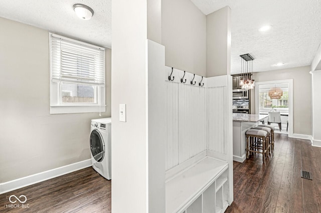 mudroom featuring washer / clothes dryer, a textured ceiling, a notable chandelier, and dark wood-type flooring
