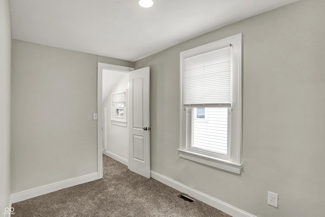 734 N Bradley Ave, Indianapolis, IN 46201 - spare room featuring baseboards, dark carpet, and visible vents