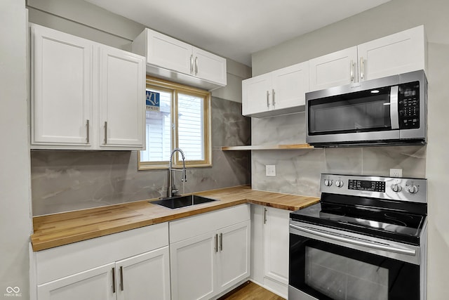 734 N Bradley Ave, Indianapolis, IN 46201 - kitchen with wood counters, appliances with stainless steel finishes, white cabinets, and a sink