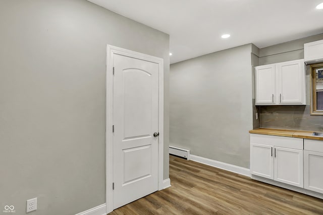 734 N Bradley Ave, Indianapolis, IN 46201 - interior space with wood finished floors, recessed lighting, baseboard heating, white cabinets, and baseboards