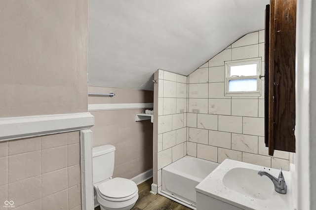 734 N Bradley Ave, Indianapolis, IN 46201 - full bathroom with toilet, a bath, vanity, vaulted ceiling, and wood finished floors