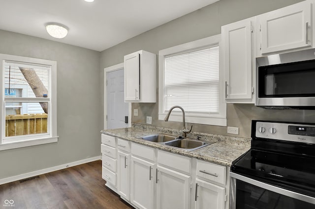 734 N Bradley Ave, Indianapolis, IN 46201 - kitchen featuring a sink, white cabinetry, visible vents, baseboards, and appliances with stainless steel finishes