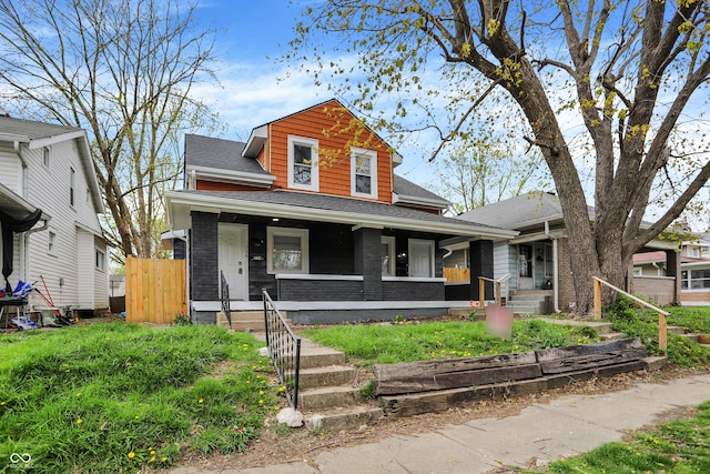 734 N Bradley Ave, Indianapolis, IN 46201 - view of front of home featuring roof with shingles, a porch, brick siding, and fence