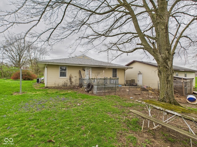 back of property with a yard and central AC
