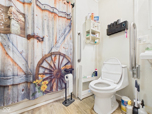 bathroom featuring wood finished floors and toilet
