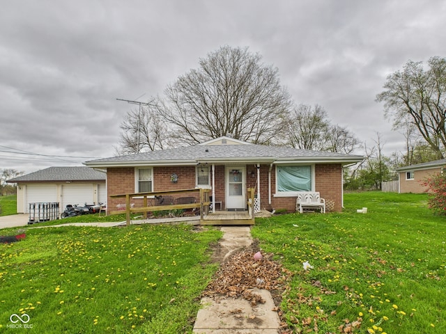 view of front facade featuring a front lawn, brick siding, and a detached garage