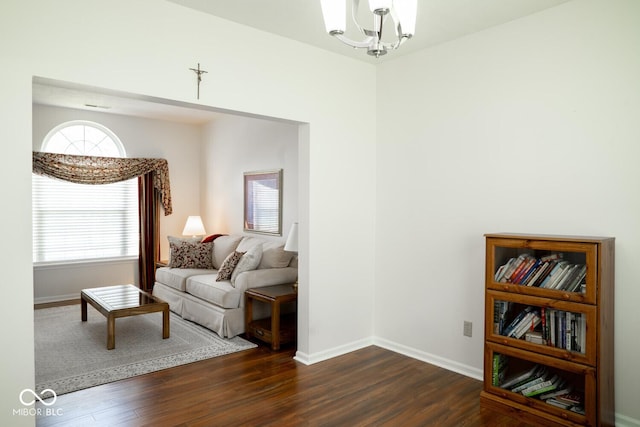 living area with a notable chandelier, dark wood-style floors, and baseboards